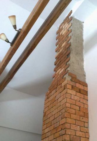 V dnevni sobi se je na dimnik nalepilo tanko opeko manjšega formata in popestrilo prostor. Opeka gre lepo skupaj s starimi špirovci.